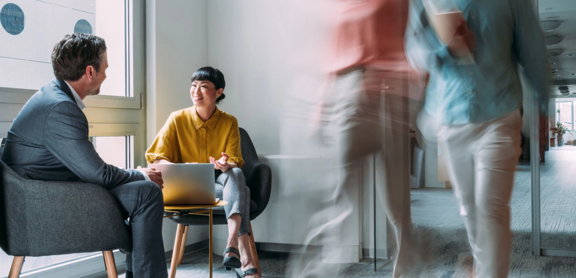 Business partners sitting together in a busy office.